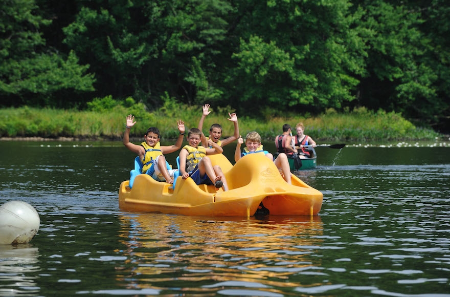 Jewish campers on a pedal boat show their enthusiasm at NYJ Cedar Camp in New Jersey. (Foundation for Jewish Camp) 