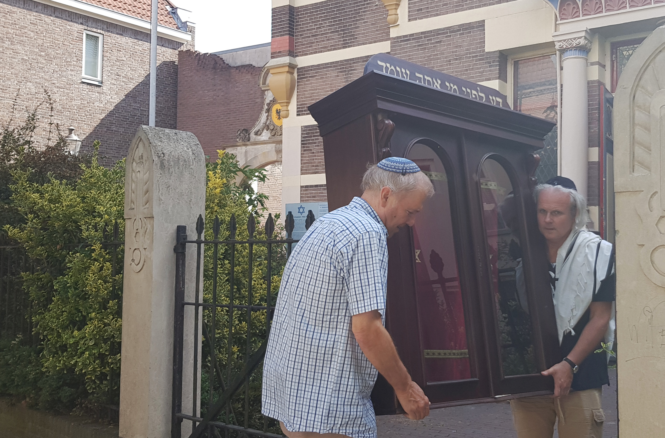Tom Furstenberg, right, and a member of the Jewish community of Deventer carrying away the Torah ark of their former synagogue on July 30, 2018. Cnaan Liphshiz