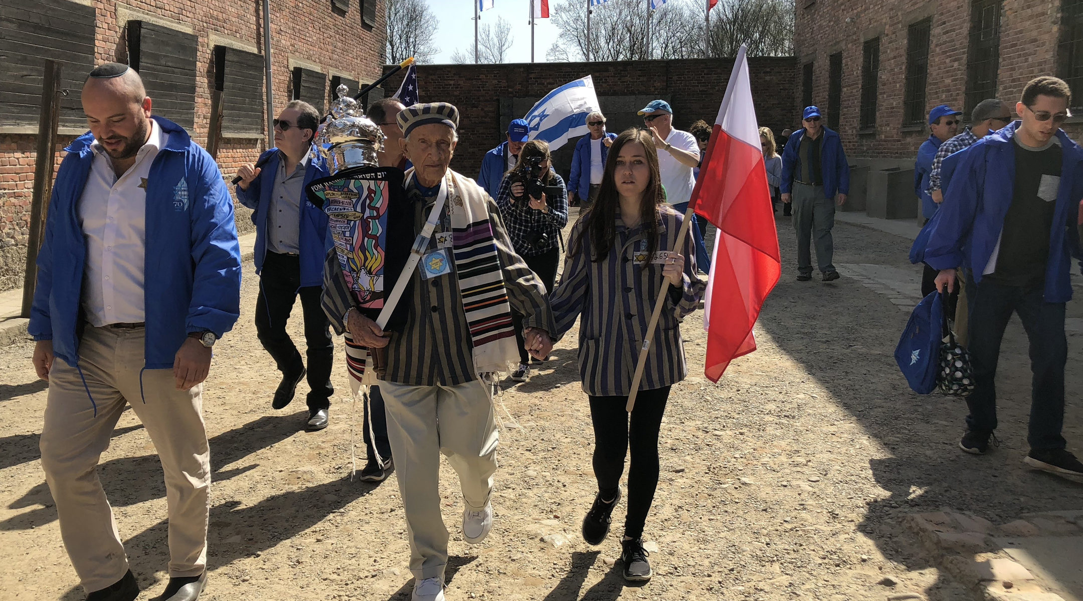 Edward Mosberg, holding a Torah scroll, during March of the Living in 2017 at the former death camp Auschwitz in Poland. (Courtesy of From the Depths)