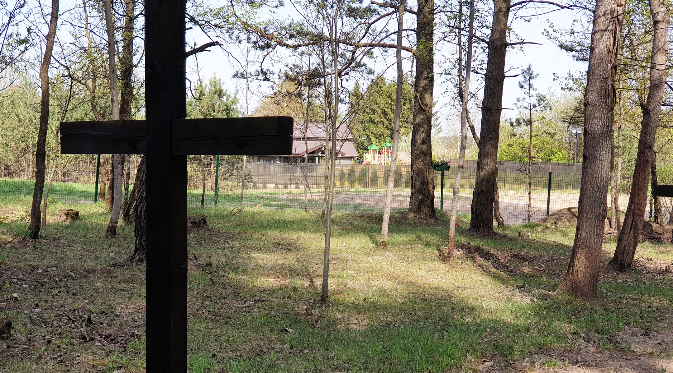 At the Kuropaty execution site, the children's amusement park of a new restaurant built in 2018 overlooks wooden crosses for the victims of Stalinism. (Cnaan Liphshiz) 