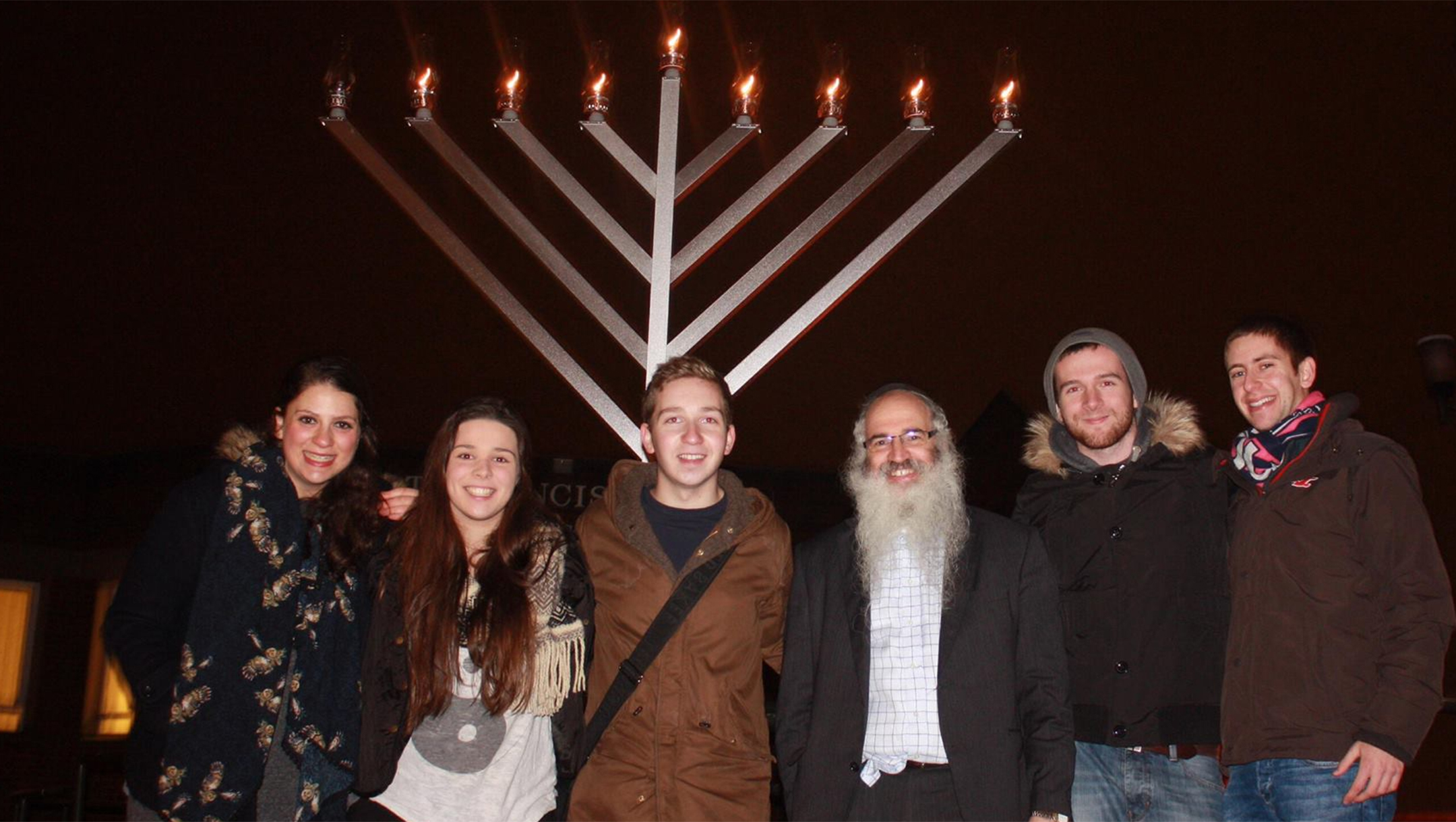 Rabbi Fishel Cohen with Jewish students at a candle lighting ceremony in Hanukka in Birmingham, the United Kingdom on Dec. 24, 2014. (Courtesy of Rabbi Fighsel Cohen /The Birmingham Tab)