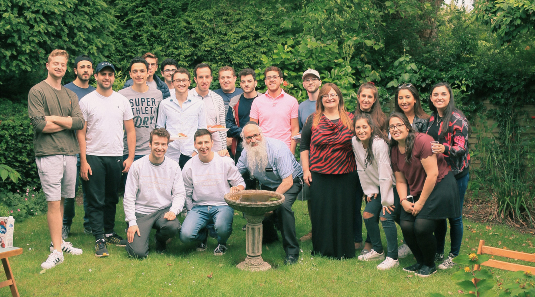 Rabbi Fishel Cohen, wearing a kippah, and his wife Esther with Birmigham university students at the local Hillel House in July 2018. (Courtesy of Rabbi Cohen)