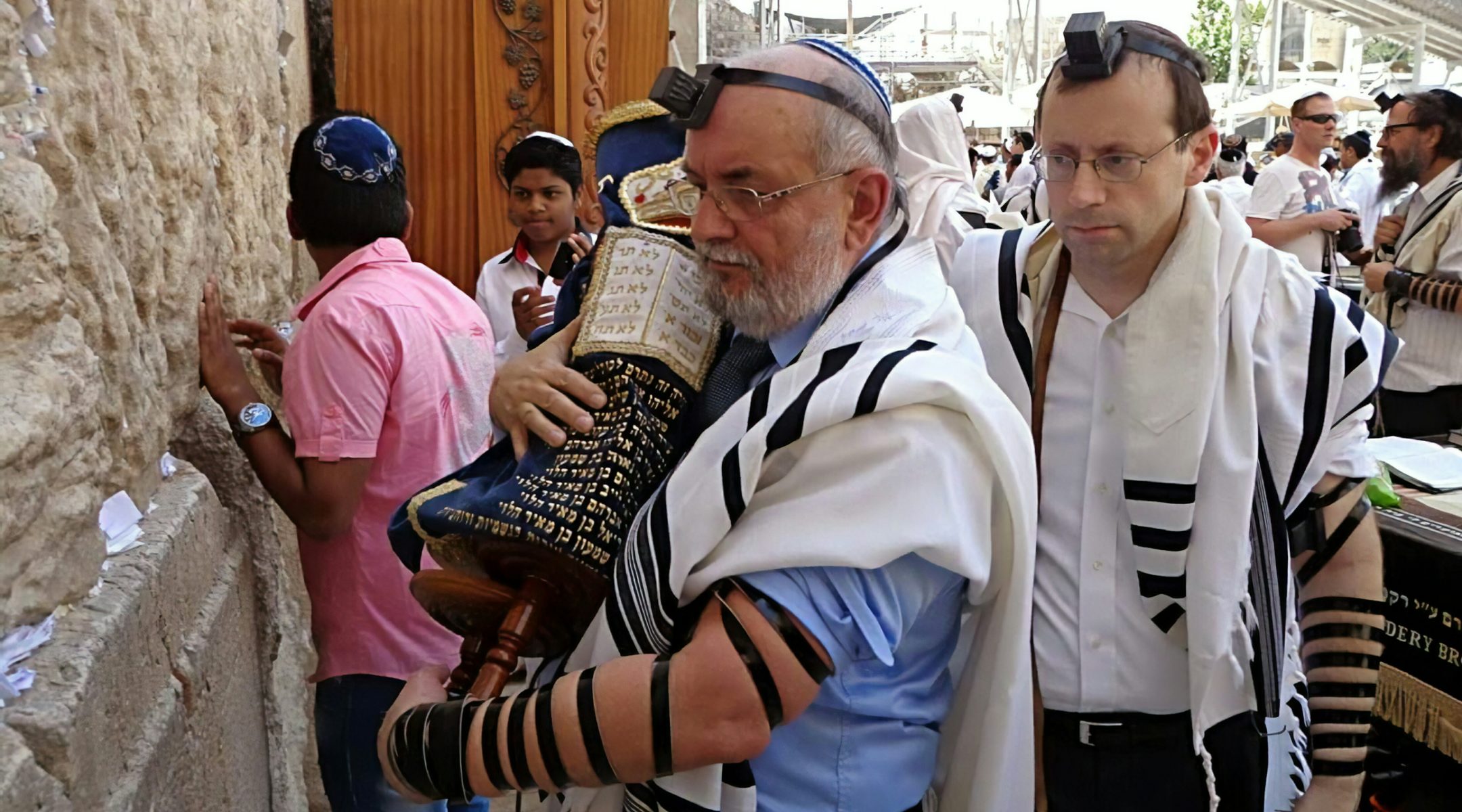 Mariusz Robert Opałko, holding a Torah scroll, and Michael Freund at the Western Wall in Jerusalem, Israel on June 9, 2013. (Courtesy of Shavei Israel)