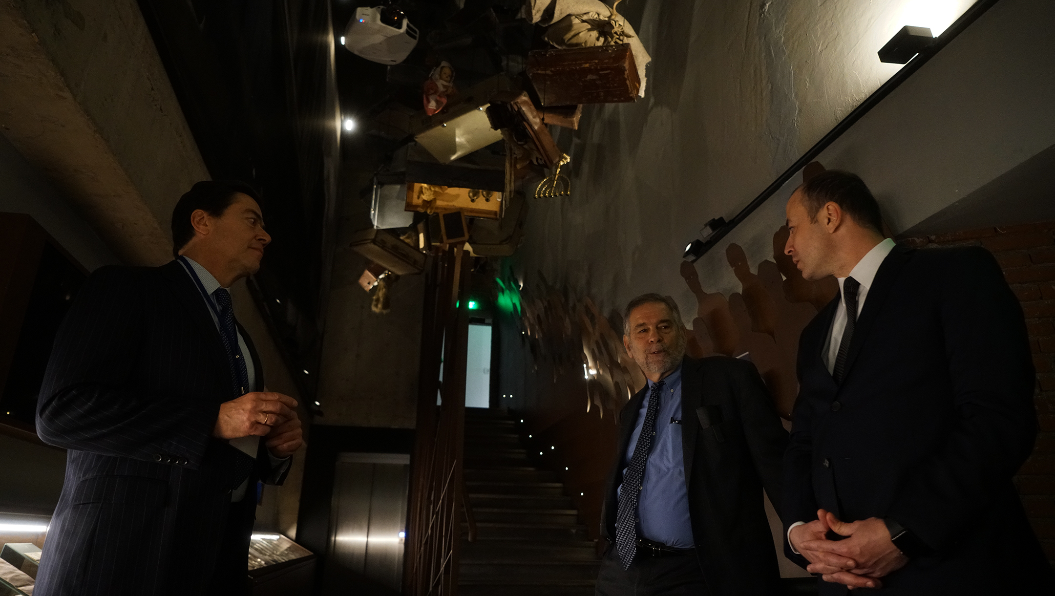 Historian Michael Berenbaum, center, speaking to designer Edward Jacobs, left, and a Romanian diplomat at Skopje's Holocaust Memorial Center for the Jews of North Macedonia on March 11, 2019. (Cnaan Liphshiz)