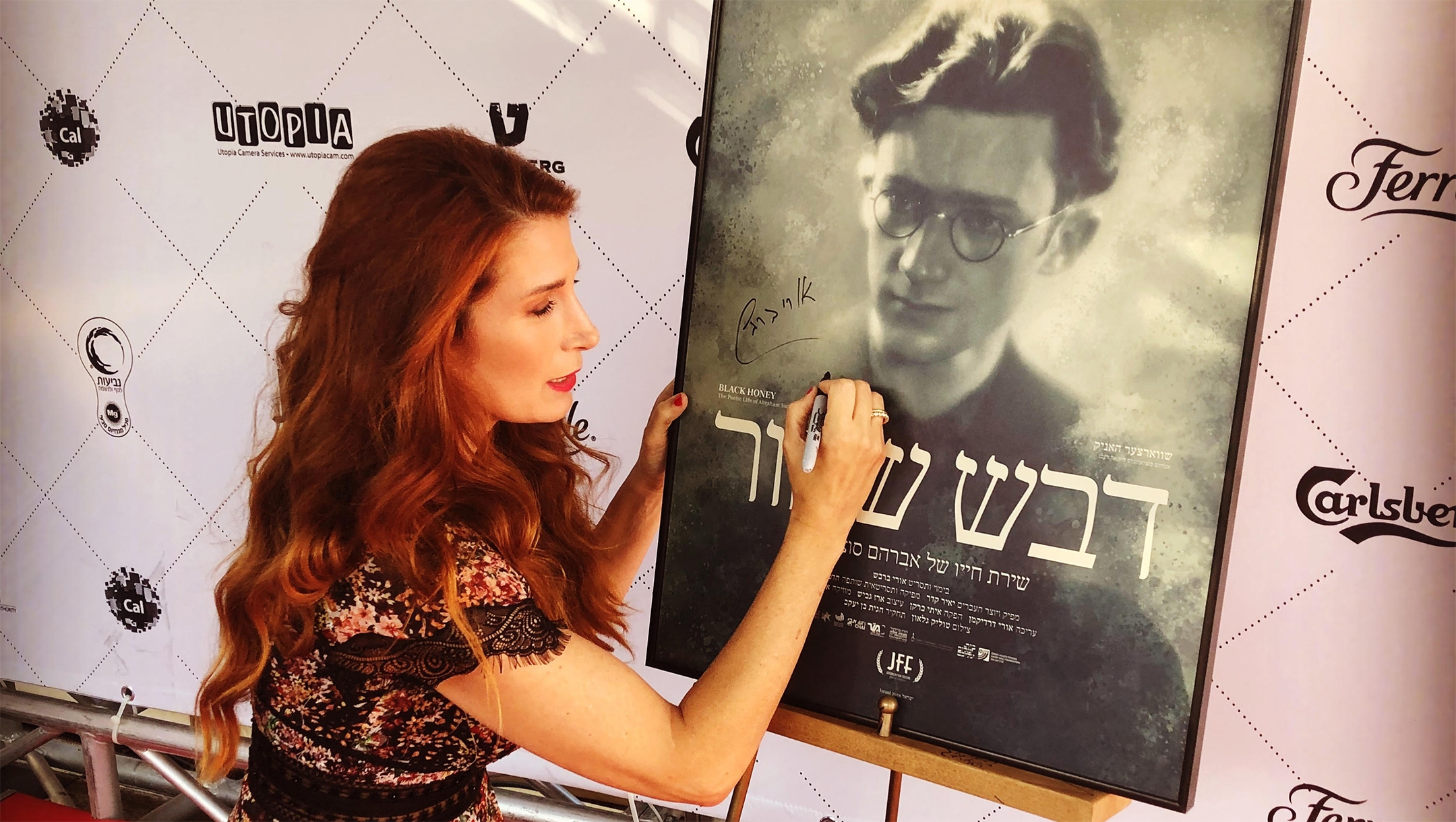 Hadas Kalderon-Sutzkever signing a poster for a new film about her grandfather Abraham Sutzkever in 2018 in Tel Aviv. Courtesy of Kalderon-Sutzkever 