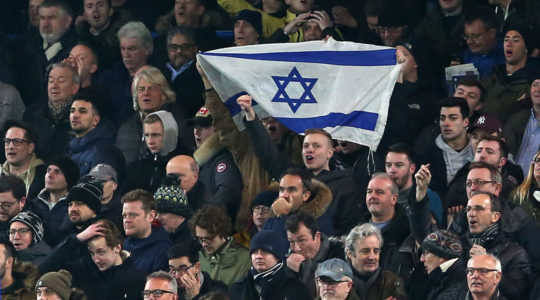 Soccer supporters hold an Israeli flag during a match between Chelsea and Tottenham Hotspur at in London, the United Kingdom on Jan. 24, 2019. (Charlotte Wilson/Offside/Getty Images)
