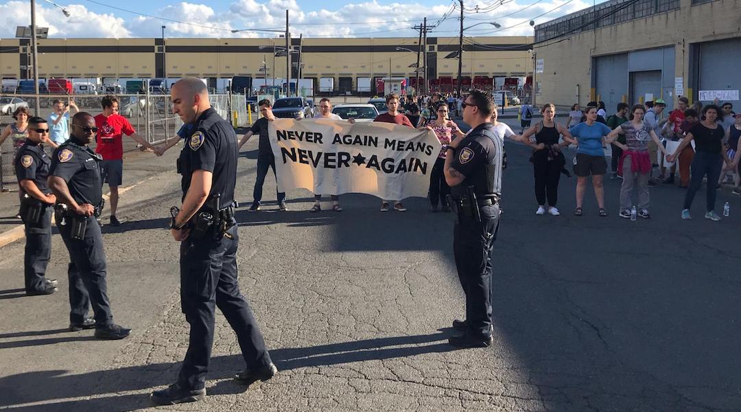 Police stand in front of protestors at a demonstration at an ICE detention center in Elizabeth, N.J. on July 7, 2019. (Naftali Y. Ehrenkranz)