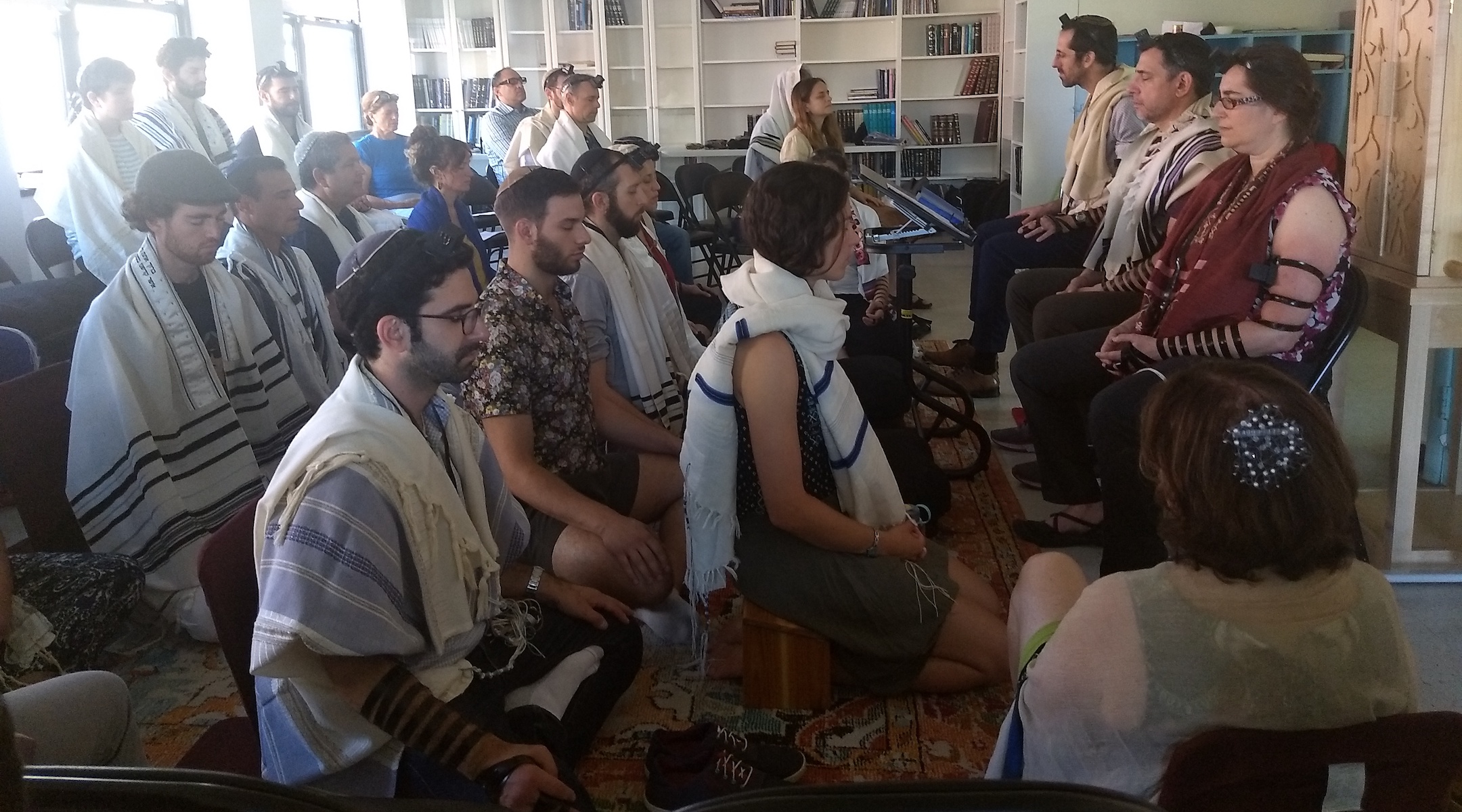 Students meditate as part of the morning prayer at Romemu Yeshiva in New York, N.Y. on July 16, 2019. The yeshiva combines intensive study of Jewish text with mindfulness and mysticism. (Ben Sales)