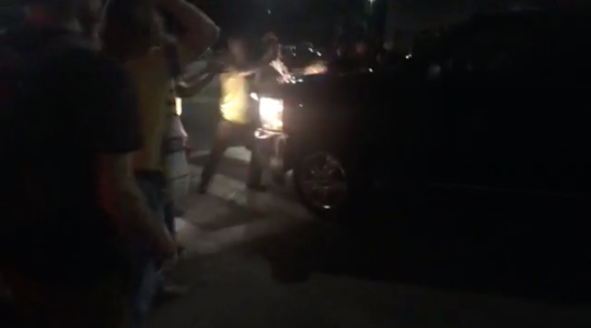 A pickup truck drives into a row of Jewish protesters sitting at the entrance to a parking lot outside an Immigration and Customs Enforcement detention facility in Central Falls, Rhode Island on August 14, 2019. (Screenshot from Facebook)