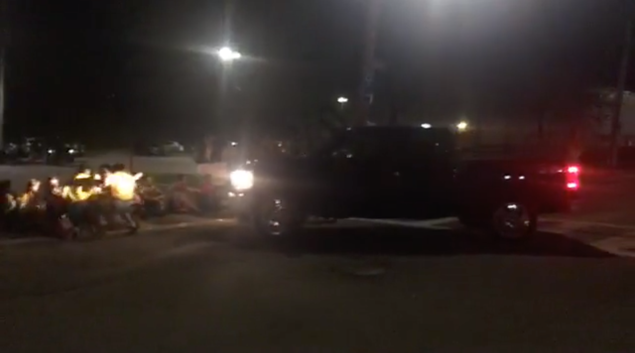 A pickup truck drives into a row of Jewish protesters sitting at the entrance to a parking lot outside an Immigration and Customs Enforcement detention facility in Central Falls, Rhode Island on August 14, 2019. (Screenshot from Facebook)