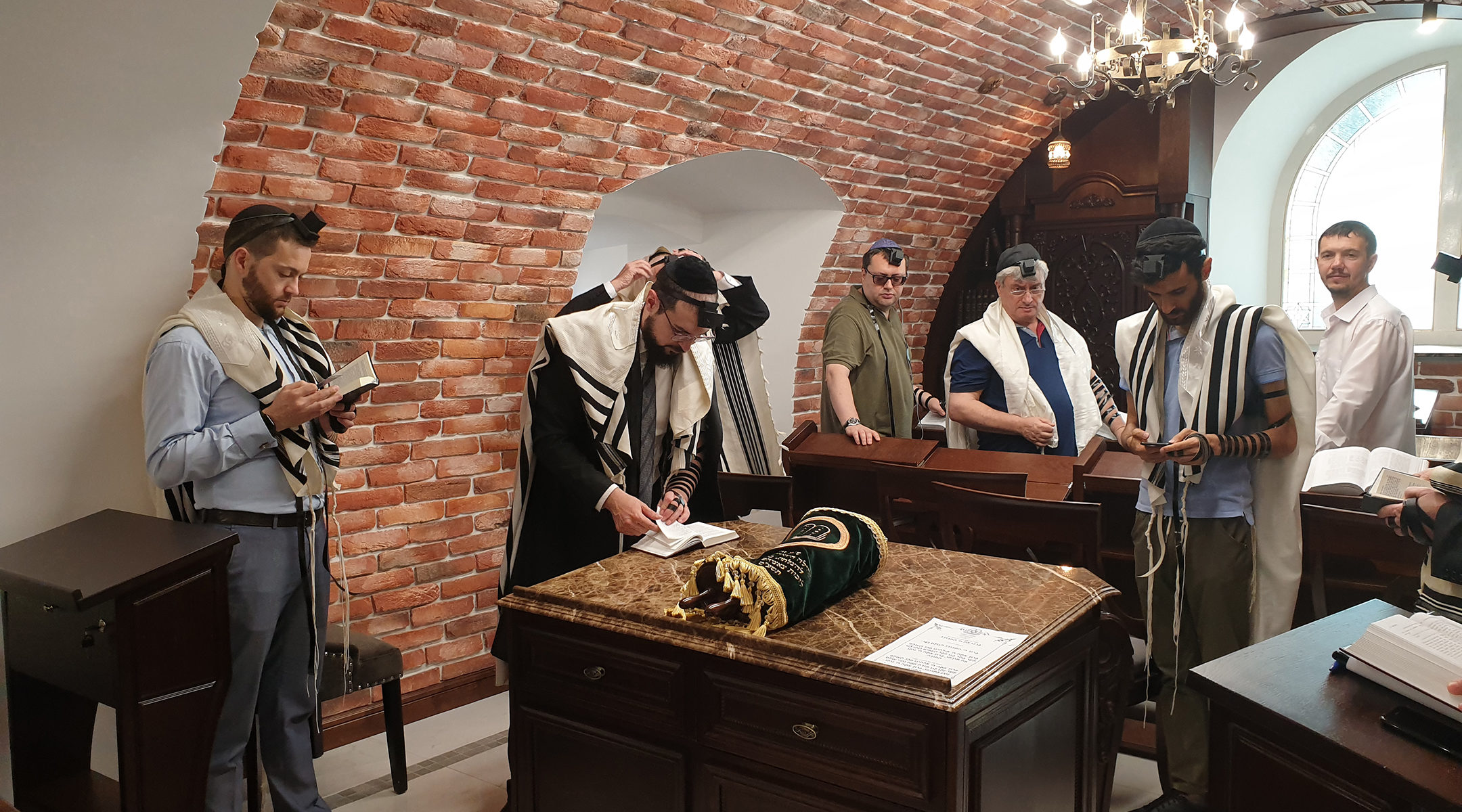 Rabbi Shimshon Izakson, second from left, praying with congregants at the Wooden Synagogue in Chisinau, Moldova on Aug. 26, 2019. (Cnaan Liphshiz)