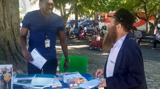 Rabbi Eli Cohen (right), the executive director of the Crown Heights Community Center, talks with a census volunteer at the #OneCrownHeights festival in Brooklyn, New York on Sunday, September 15, 2019. (Ben Sales)
