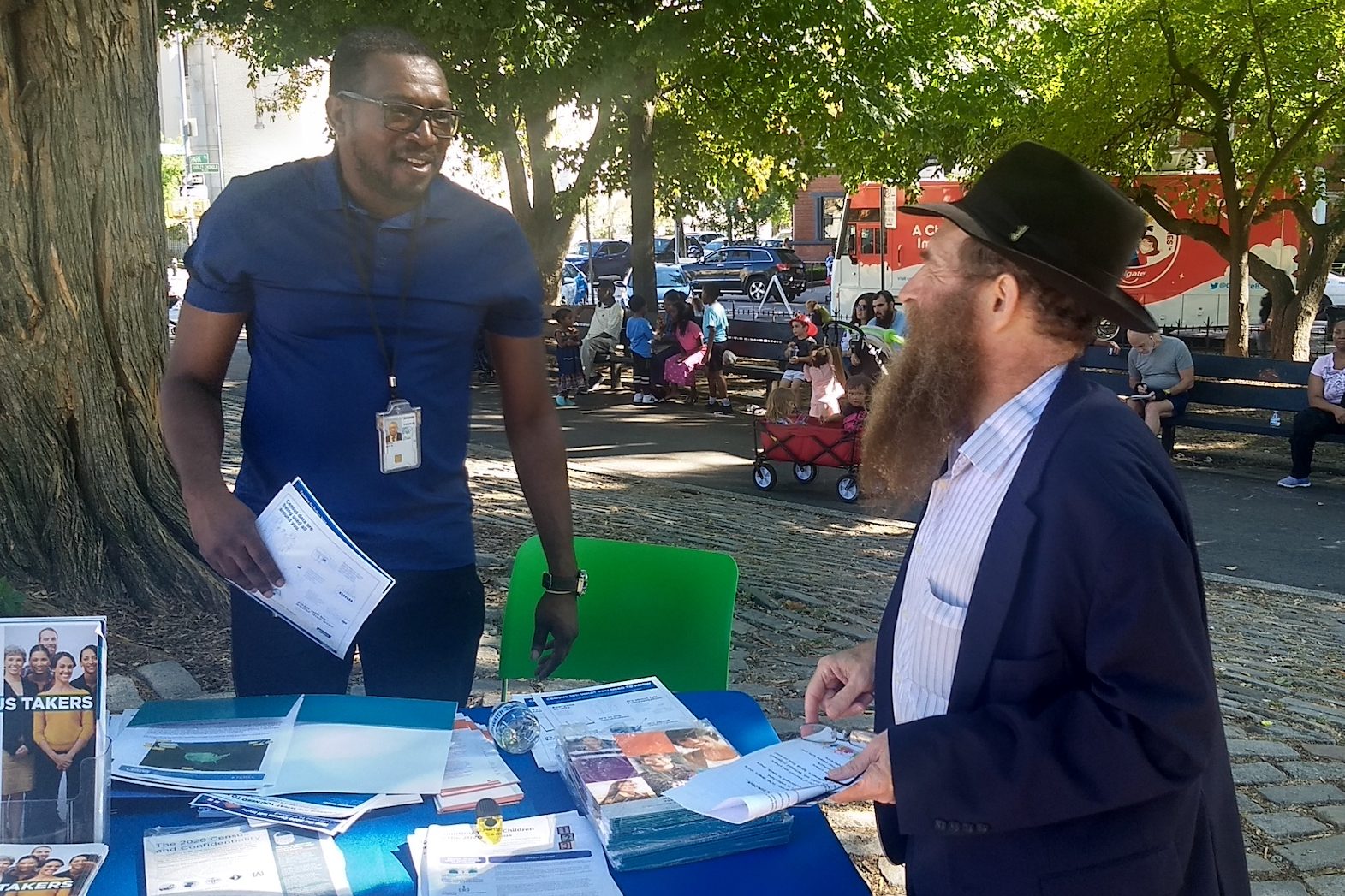Rabbi Eli Cohen (right), the executive director of the Crown Heights Community Center, talks with a census volunteer at the #OneCrownHeights festival in Brooklyn, New York on Sunday, September 15, 2019. (Ben Sales)