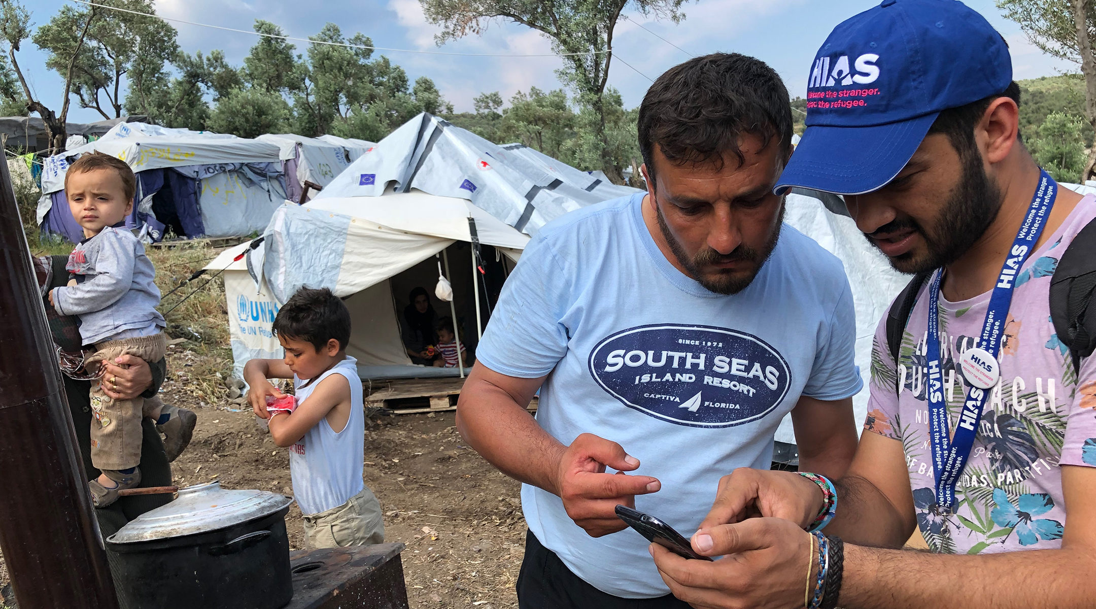 HIAS Greece translator Jalal Barezkai, right, assisting a Syrian refugee in an encampment near the Moria refugee camp on the island of Lesvos, Greece on May 9, 2018. (Bill Swersey/HIAS)