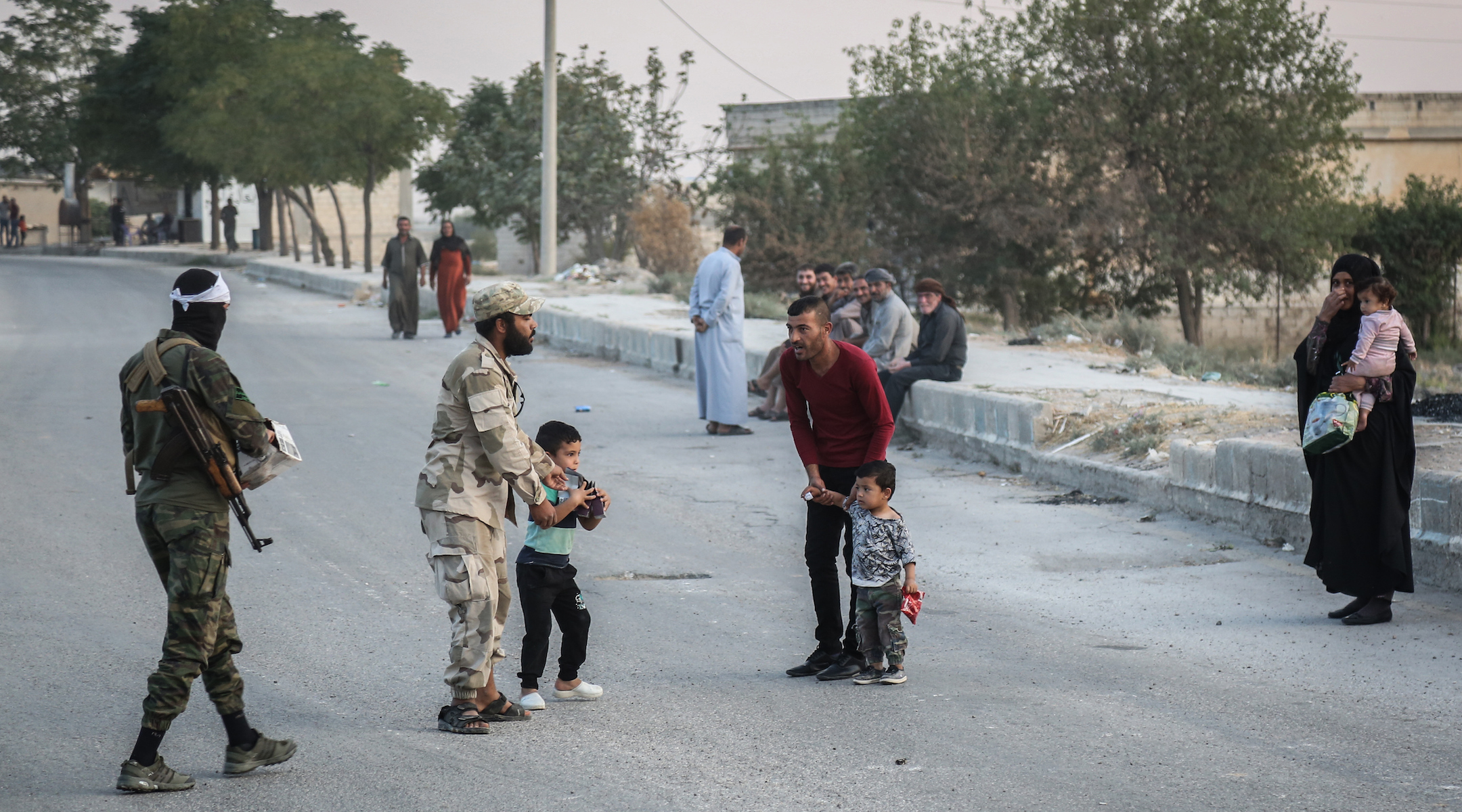 Soldiers of the Turkish-backed Syrian National Army talk to local residents in Tel Abiad, Syria on Oct. 14, 2019. (Anas Alkharboutli/Getty Images)