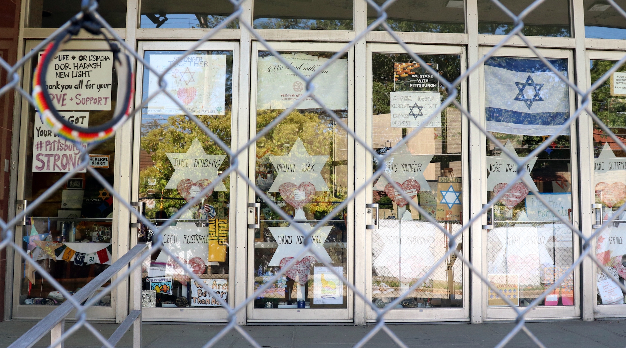 The doors of the Tree of Life synagogue, the site of a shooting attack last October, have remained closed, with memorials surrounding the building. (Grace Yagel)