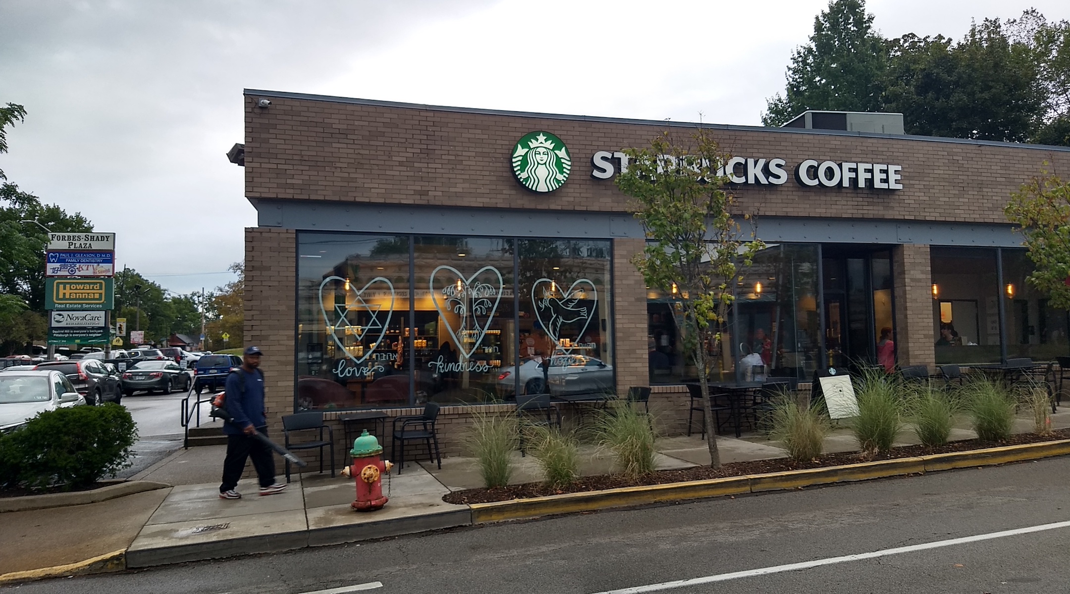 The window of the Starbucks in Squirrel Hill bears three hearts with the words "love," "kindness" and "hope" written in English and Hebrew. (Ben Sales)
