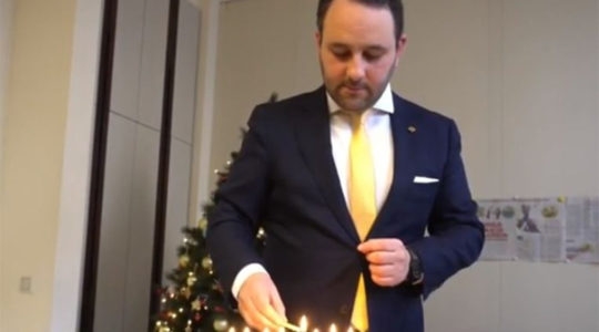 Michael Freilich lighting Hanukkah candles in the Belgian federal parliament in Brussels, Belgium on Dec. 19, 2019. (Michael Freilich)