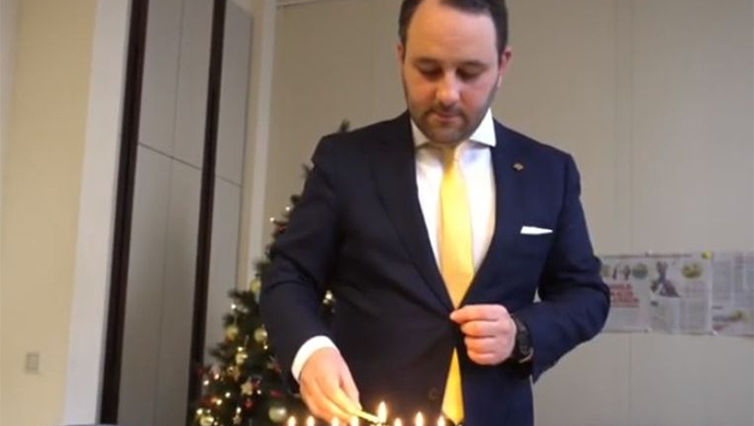 Michael Freilich lighting Hanukkah candles in the Belgian federal parliament in Brussels, Belgium on Dec. 19, 2019. (Michael Freilich)