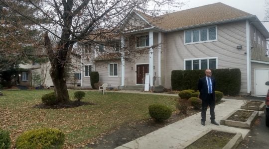 A security guard stands outside the rabbi's house where Saturday's stabbing took place. (Ben Sales)