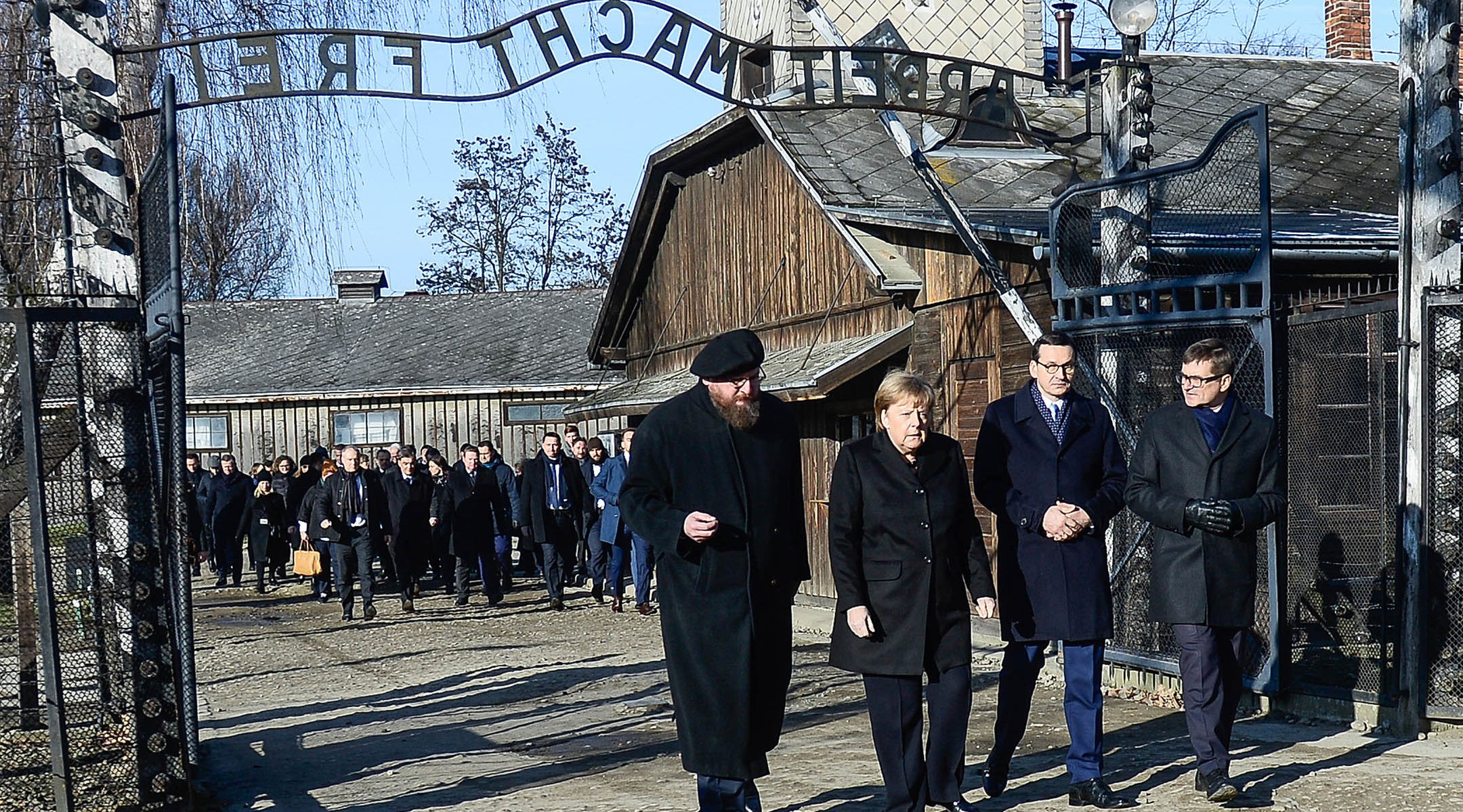 German Chancellor Angela Merkel and Poland's Prime Minister, Mateusz Morawiecki, second from left, receiving a tour by employees of the former Auschwitz Nazi concentration camp near Krakow, Poland on Dec. 6, 2019. (Omar Marques/Getty Images)