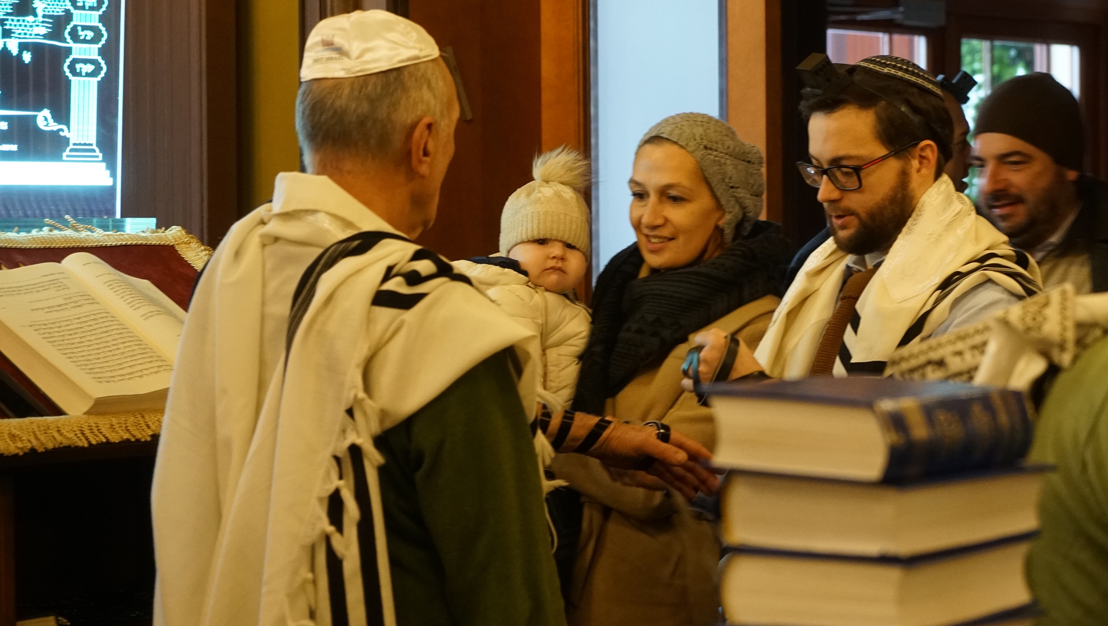 Rabbi Shimon Kutnovsky-Liak, waering glasses, praying with congregants at his synagogues in Jurmala, Latvia on Oct. 30, 2019. (Cnaan Liphshiz)