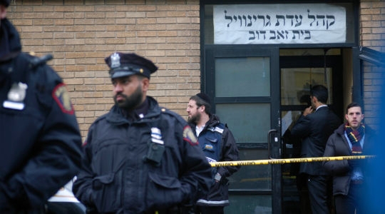 Hasidim, government officials and police officers stand in front of the K'hal Adas Greenville synagogue next door to JC Kosher Supermarket in Jersey City, the site of a deadly shooting, Dec. 11, 2019. (Laura E. Adkins/JTA)