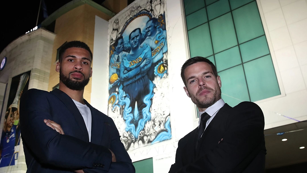 Chelsea soccer players Cesar Azpilicueta, right, and Ruben Loftus-Cheek standing against the club's mural commemorating Holocaust victims in London, UK on Jan. 15, 2020.. (Courtesy of Chelsea FC)