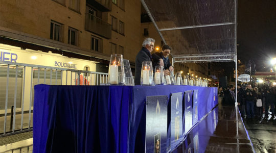 Senior French government official Emmanuelle Wargon and CRIF board member Serge Dahan lighting a memorial candle outside the Hyper Cacher store in Paris, France on Jan. 9, 2020. (Courtesy of CRIF)