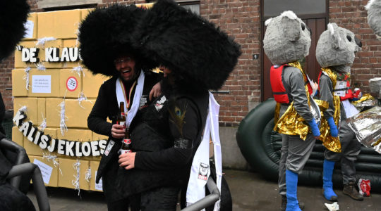 Men wearing a haredi Jews suit with an ant's abdomen and legs at the annual procession of the carnival in Aalst, Belgium on Feb. 23, 2020. (Cnaan Liphshiz)