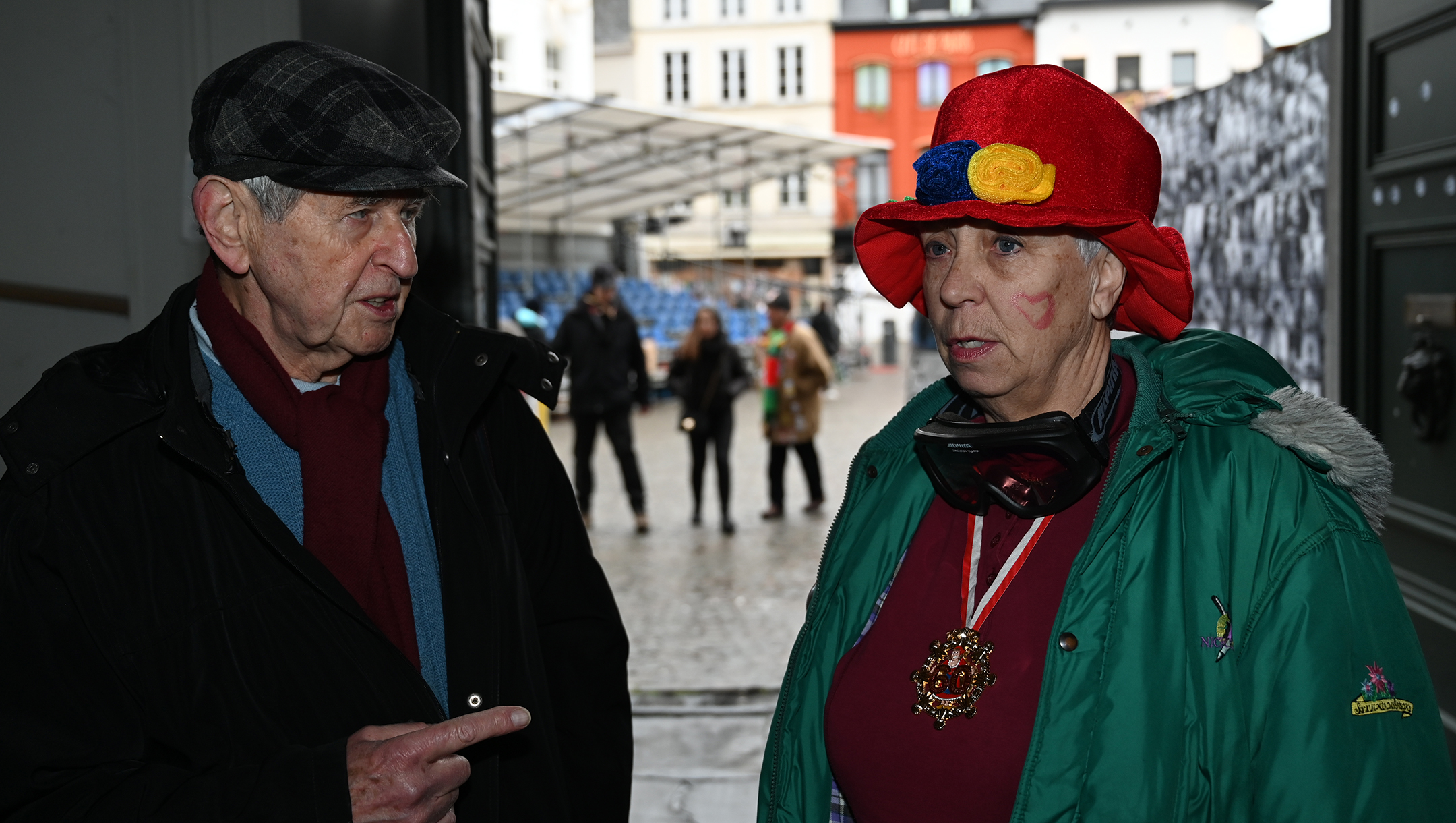 Greet Stevens, right, speaking to Rudi Roth, a Belgian-Jewish journalist, while wearing blackened goggles to protest perceived anti-Semitism at the carnival of Aalst, Belgium on Feb. 23, 2020. (Cnaan Liphshiz)