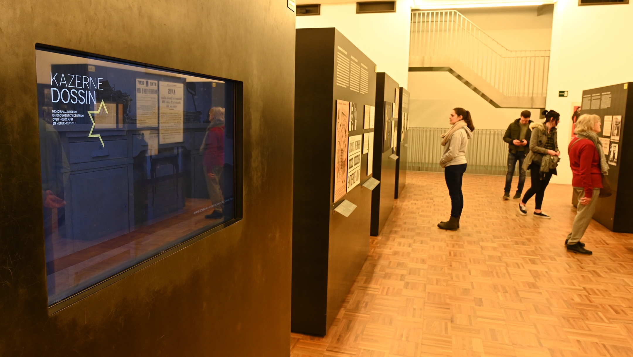 A woman reads about Belgian Jews the Kazerne Dossin Holocaust museum in Mechelen, Belgium on Dec. 22, 2019. (Cnaan Liphshiz)