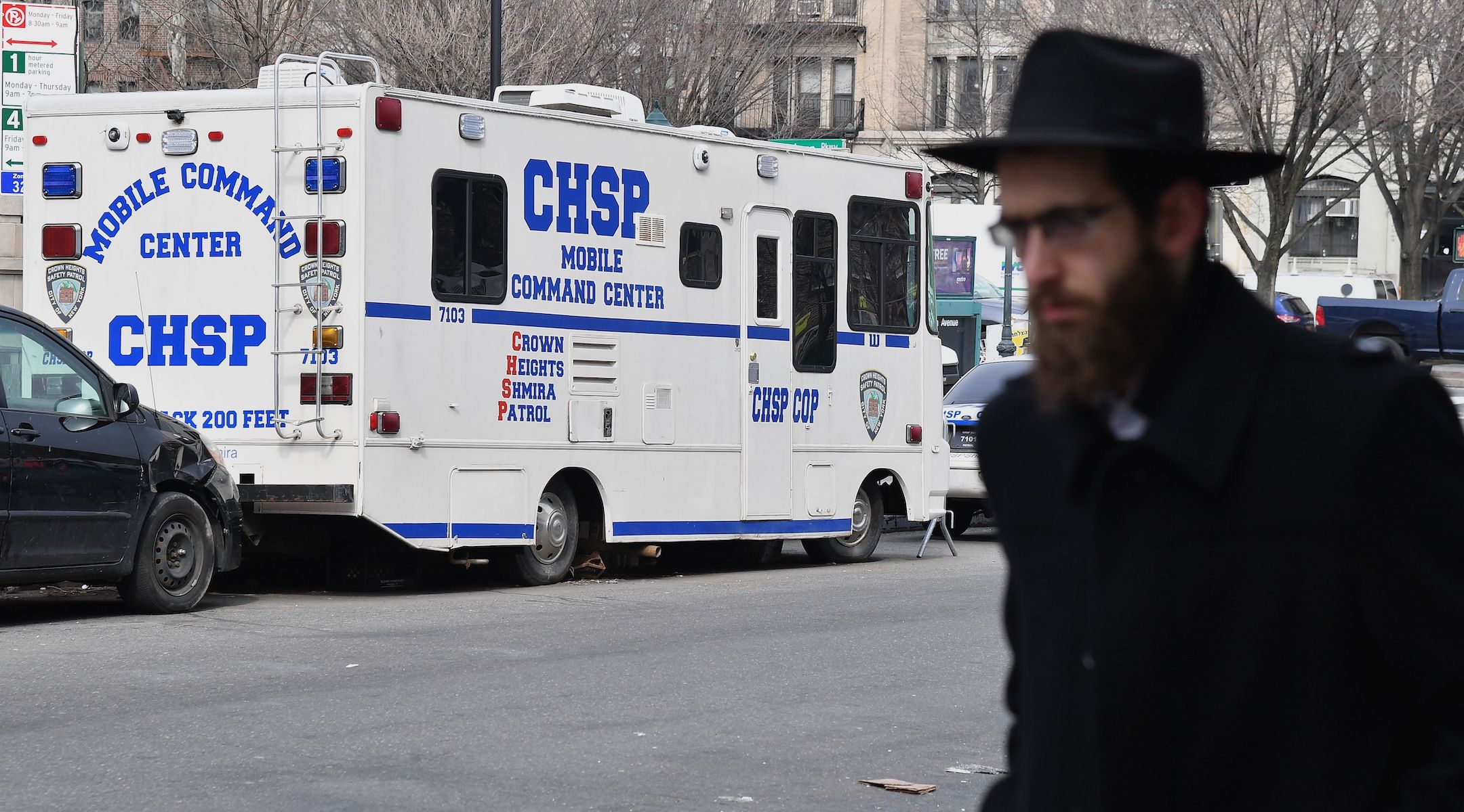An Orthodox Jew walks past a Crown Heights Shmira Patrol security vehicle in the Brooklyn neighborhood of Crown Heights on February 27, 2019. (Angela Weiss//AFP via Getty Images)