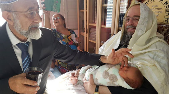 Rabbi Avraham Yeshayahu, right, Heber holding the son of a kidney donor during his Brith Milah in Jerusalem, Israel on Oct. 14, 2018. (Courtesy of Matnat Chaim)