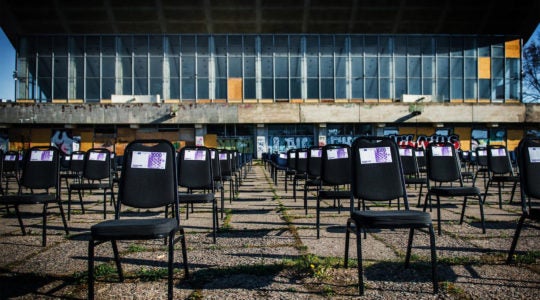 Chairs with fake money notes standing next to the decaying Palace of Concerts and Sports of Vilnius, Lithuania on May 1, 2020. (Courtesy of the display's organizers)