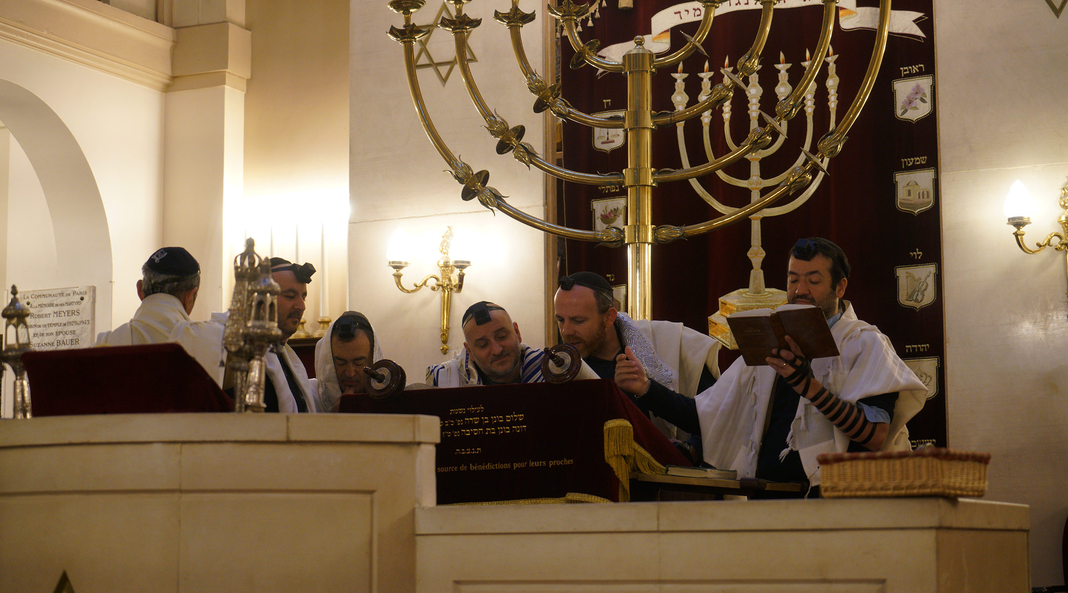 Rabbi Michael Azoulay, second from right, reading the Torah with congregants at the synagogue of Neuilly-sur-Seine, Dec. 11, 2017. (Cnaan Liphshiz)