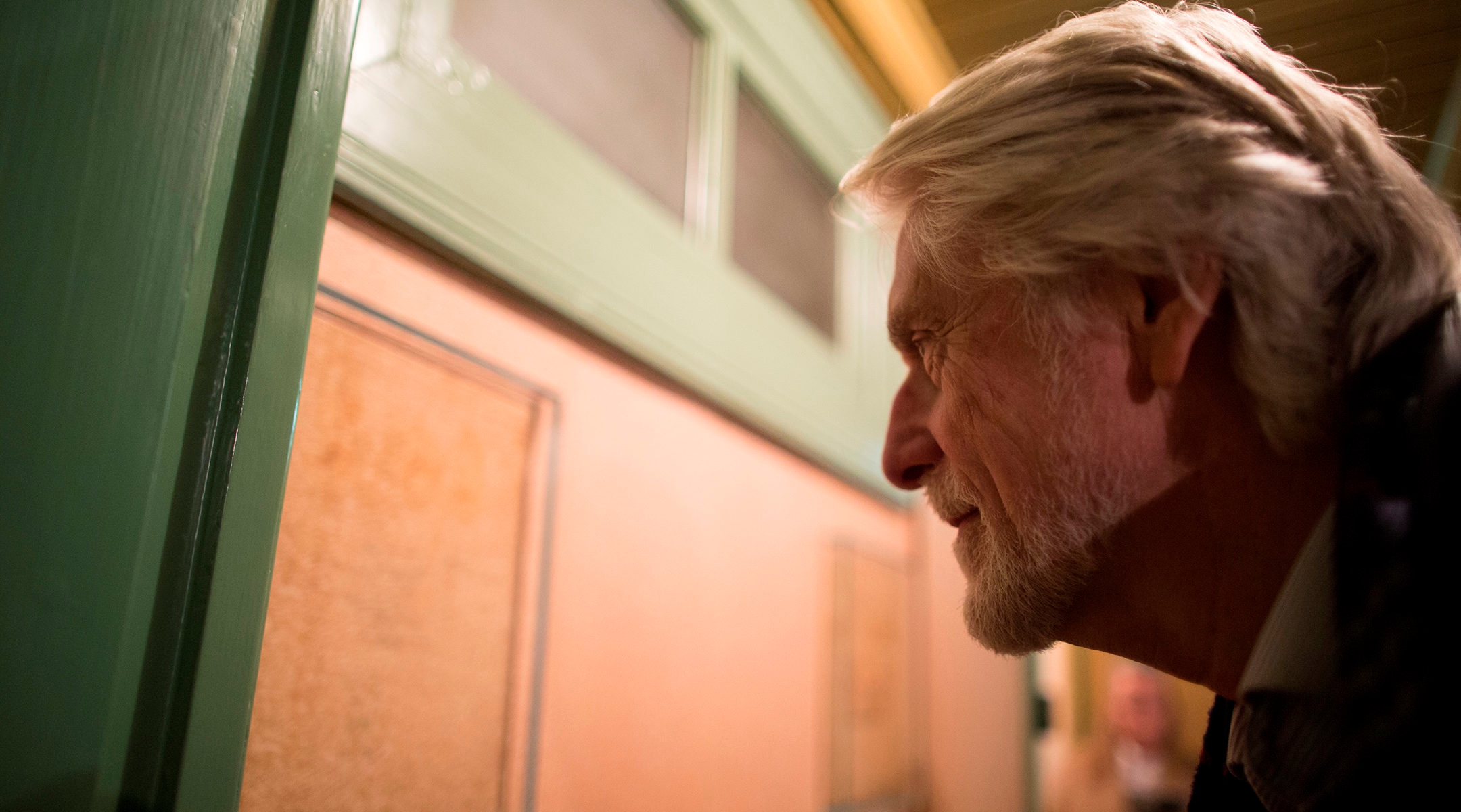 A visitor examines pencill marks measuring the grwoth of Anne and Margot Frank in what used to be their parents' room at the Anne Frank House museum in Amsterdam, the Netherlands on Nov. 24, 2016. (Photo Collection Anne Frank House)