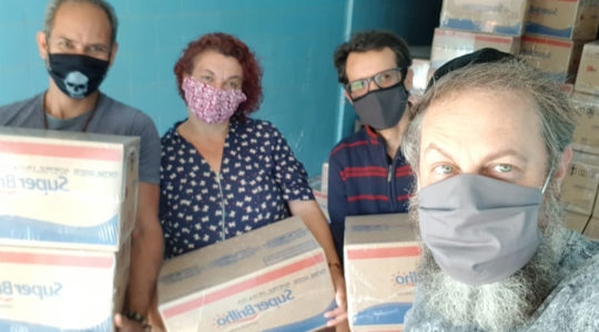 Rabbi Gilberto Ventura, right, and volunteers prepare to dispatch food packages to a needy residents of Sao Paulo, Brazil on May 27, 2020. (Courtesy of Sinagoga sem Fronteiras)