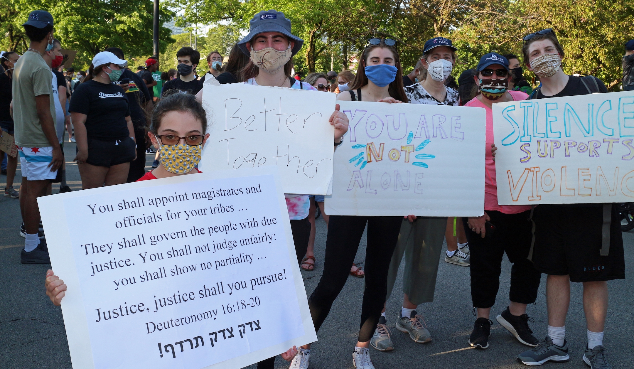 Demonstrators hold up signs at the protest. (Ariel Tesher)