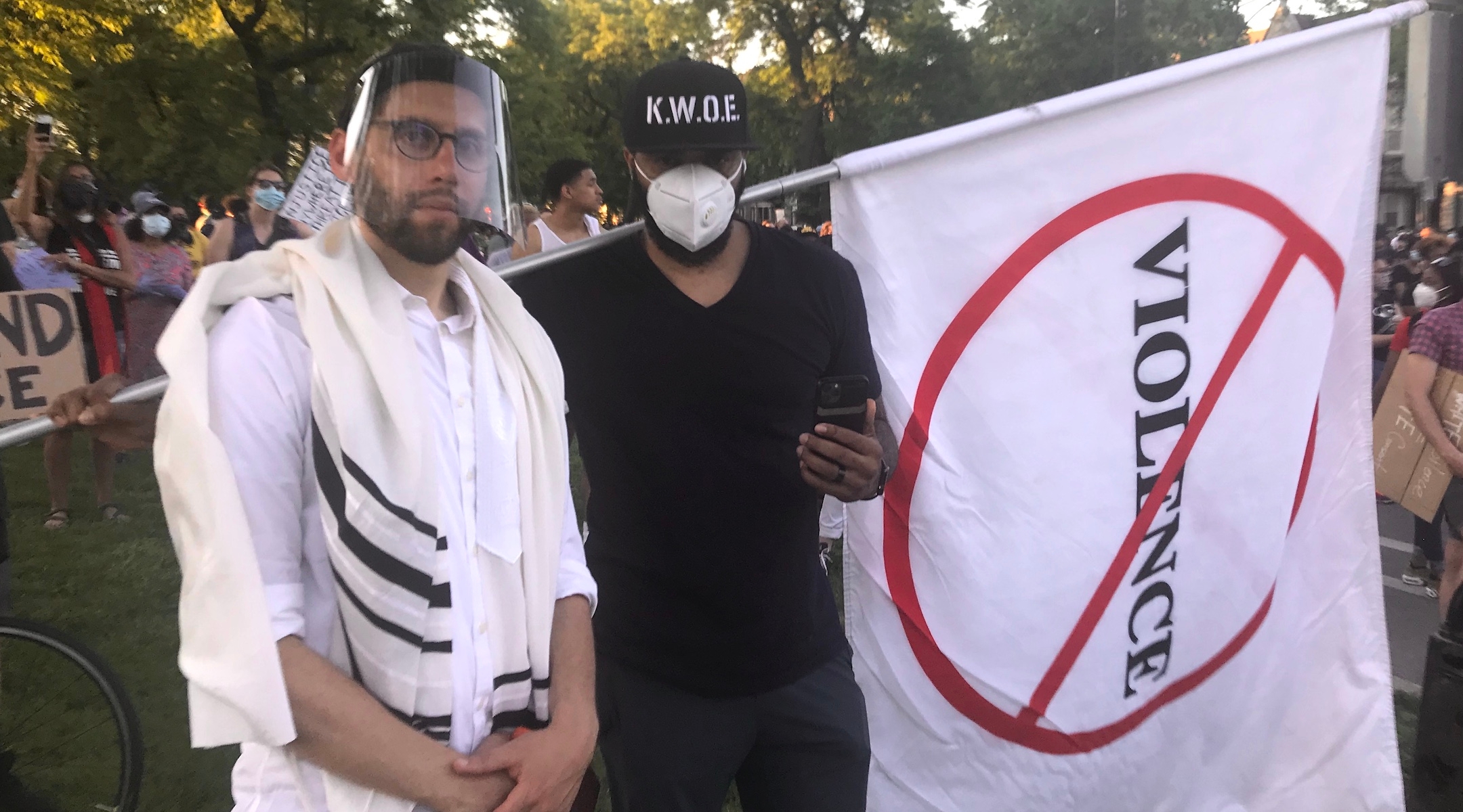 Rabbi Ari Hart, wearing a prayer shawl and face shield, stands with another protester at the interfaith demonstration in memory of George Floyd and protesting systemic racism in Chicago on June 2, 2020. (Courtesy of Hart)
