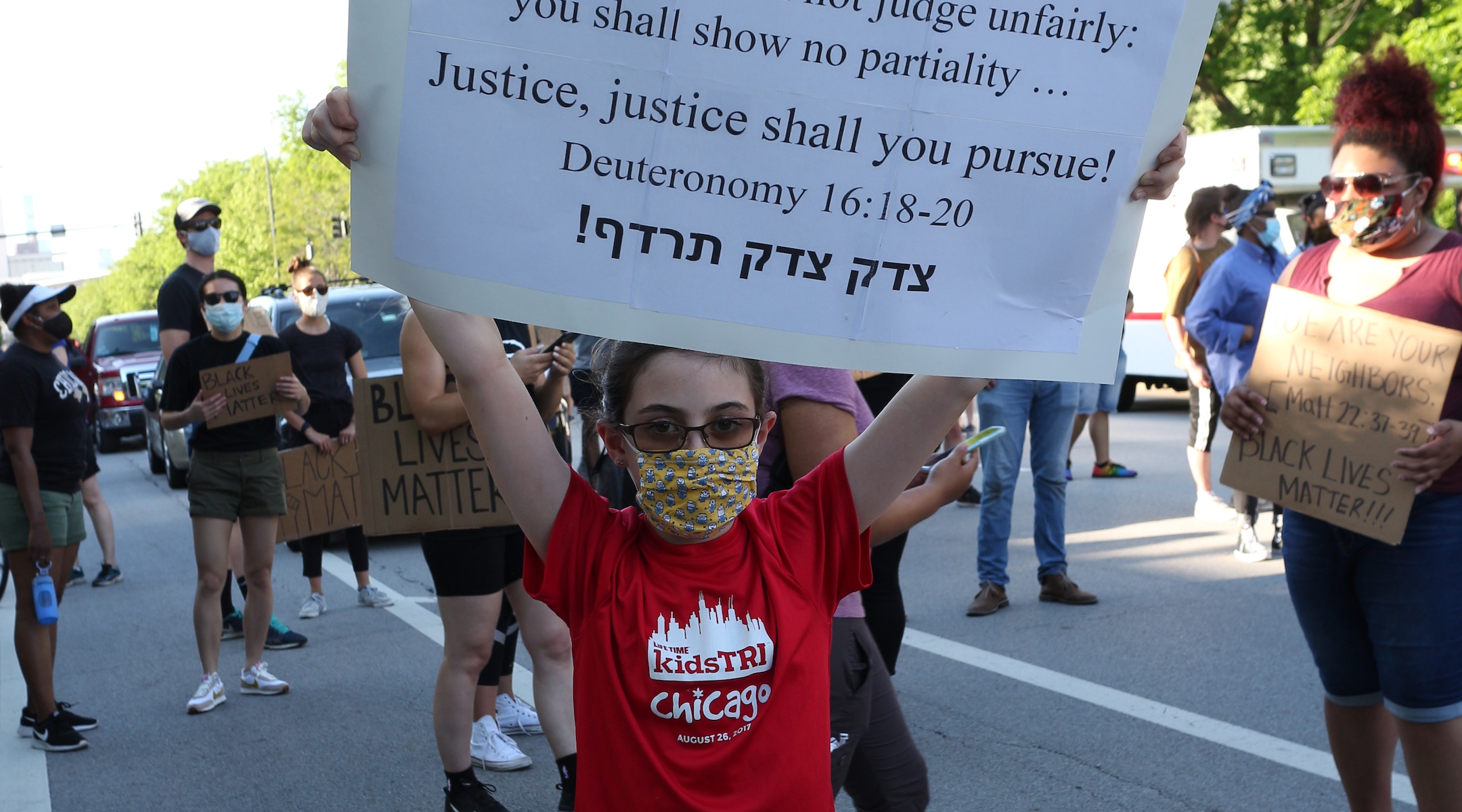 A Jewish demonstrator holds up a sign quoting the Torah in Hebrew. (Ariel Tesher)
