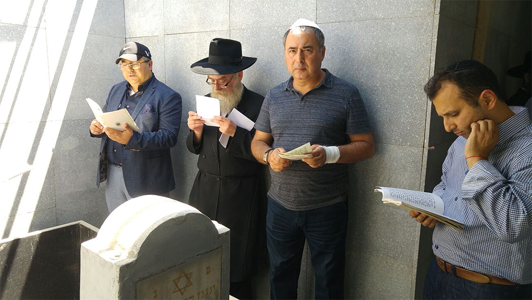 Men pray around the grave site of Levi Yitzchak Schneerson in Almaty, Kazakhstan in 2016. (Courtesy of Chabad Kazakhstan)