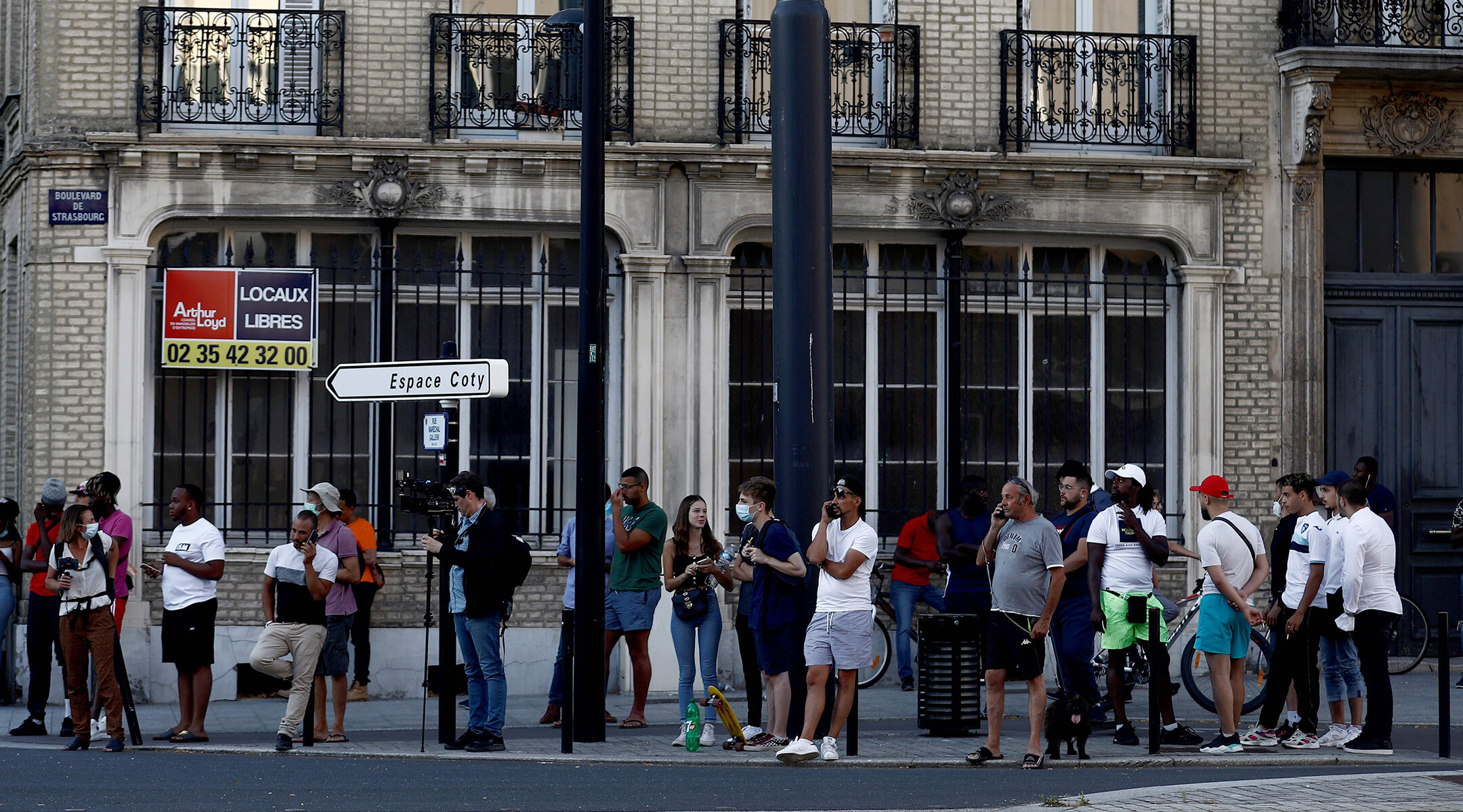 Pedestrians watch police outside a bank in Le Havre, France, where a hijacker has taken several hostages demanding the freedom of Palestinians in Israel on Aug. 7, 2020. (Sameer Al-Doumy/AFP via Getty Images)