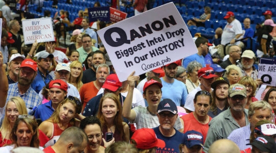 Trump supporters displaying QAnon posters at a 2018 rally in Florida. Recently, Latinos in the state have been inundared with anti-Semitic messages, many relating to the false QAnon conspiracy theory. (Thomas O'Neill/NurPhoto via Getty Images)