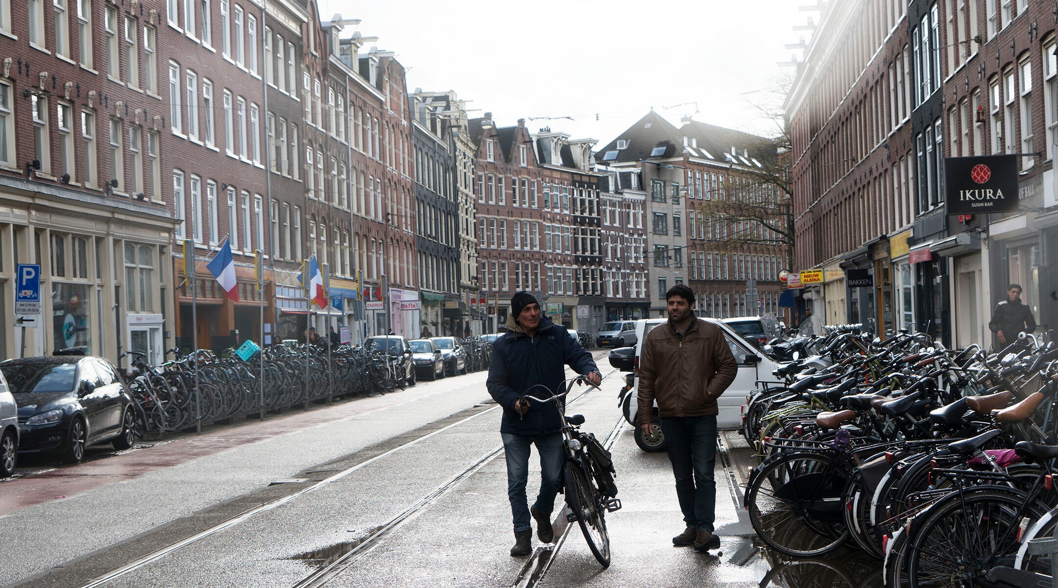 Two men walk down a street in a residential area of Amsterdam, the Netherlands on April 23, 2017. (Cnaan Liphshiz)