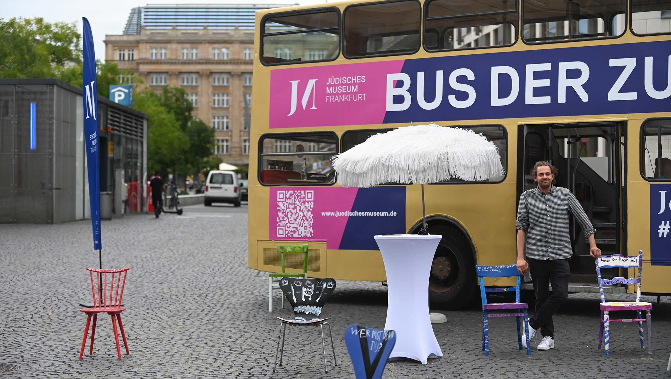 Shai Hoffman welcomes pedestrians into his Bus of Encounters in Frankfurt, Germany on Aug. 25, 2020. (Cnaan Liphshiz)