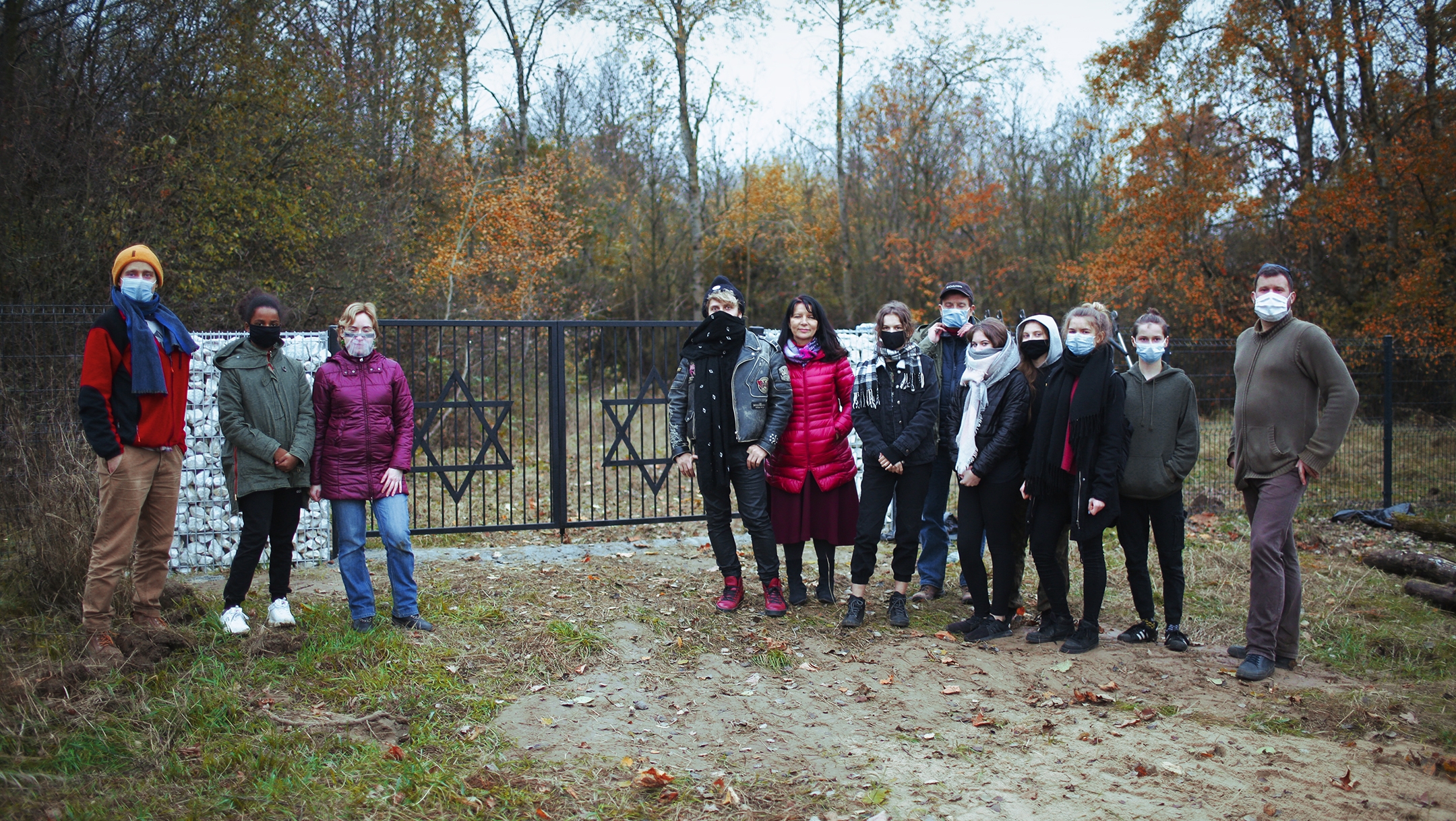 Michał Laszczkowski, right, and members of the Wagabunda Scouts troop stand in front of the Jewish cemetery of Nowe Miasto, Poland on Nov. 11, 2020. (Pawel Czarnecki)