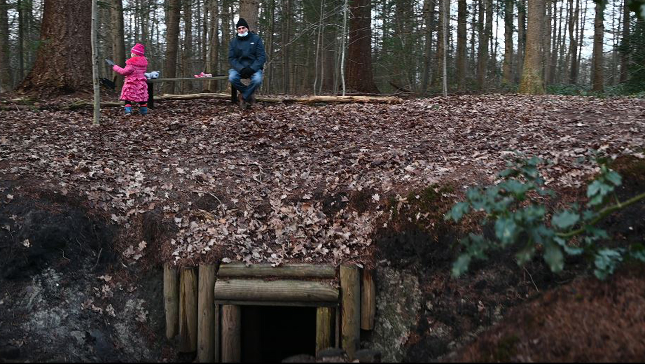 A Dutch child plays near her grandfather atop a reconstructed dugout for Jews in hiding in Nieuwlande, the Netherlands on Jan. 25, 2021. (Cnaan Liphshiz)