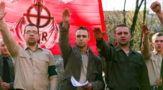 Tomasz Greniuch, holding papers, makes a gesture that appears to be a Nazi salute at a far-right event in Poland in 2007. (Bartosz Siedlik, courtesy of Gazeta Wyborcza)