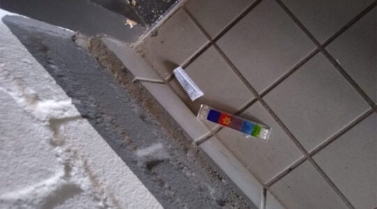 A vandalized mezuzah lies on the floor at the entrance to a Jewish student's home in Maastricht, the Netherlands on Feb. 18, 2021. (Stand With Us Netherlands)